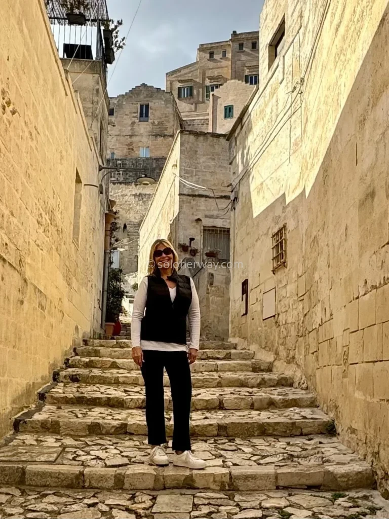 How To Handle Medical Bills and Insurance Abroad: What Every Traveler Needs To Know 7 Woman Standing on Stone Steps in Historic European Alley