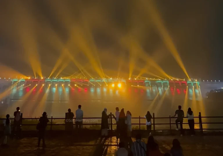 Colorful laser light show near the Statue of Unity with bright beams reflecting over the water at night
