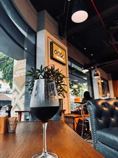 Ho Chi Minh City cafe with a chilled dark drink on a wooden table, showing a stylish indoor spot for relaxing in Saigon.