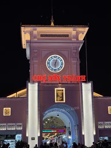 Ho Chi Minh City Ben Thanh Market clock tower lit at night, showcasing one of Saigon’s most famous landmarks and attractions